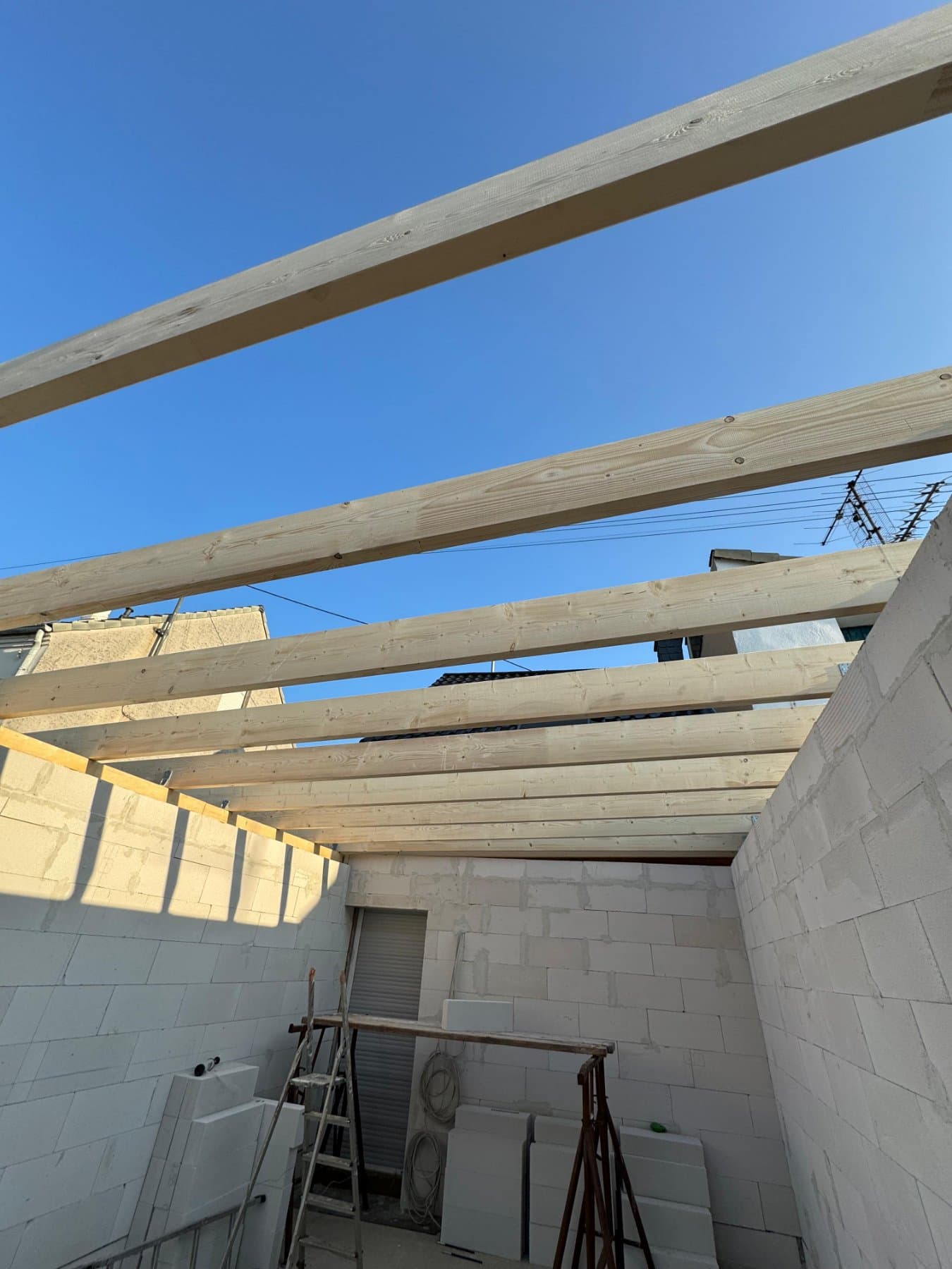 Neuer Dachstuhl aus Holzbalken auf einem Rohbau